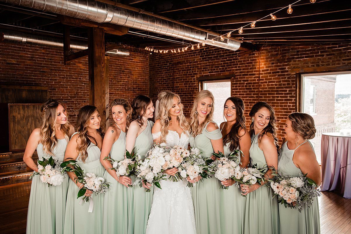 Bride surrounded by her bridesmaids who are wearing mint green chiffon dresses