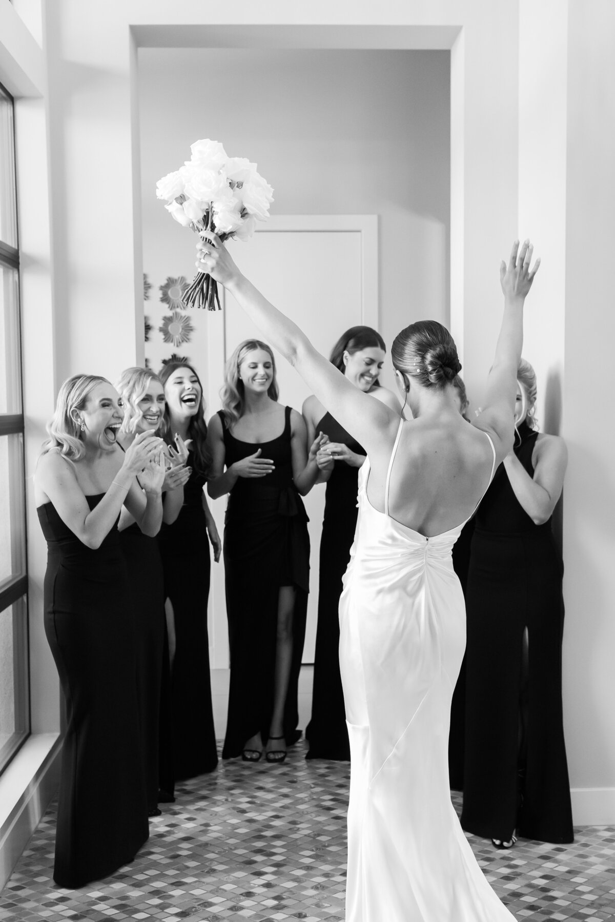 Chic bride gives her bridesmaids a first look of her in her wedding gown