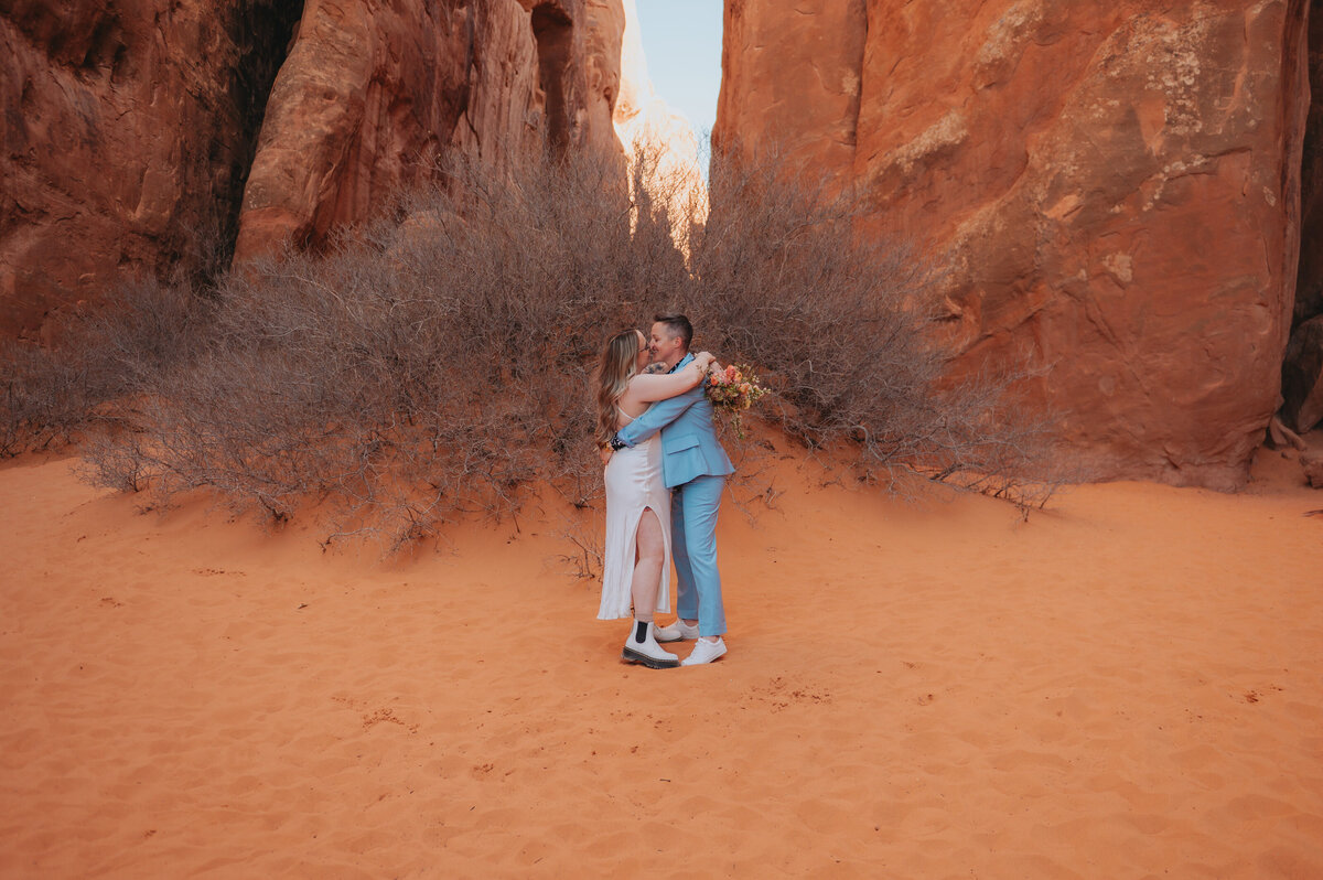A couple kisses in the sand