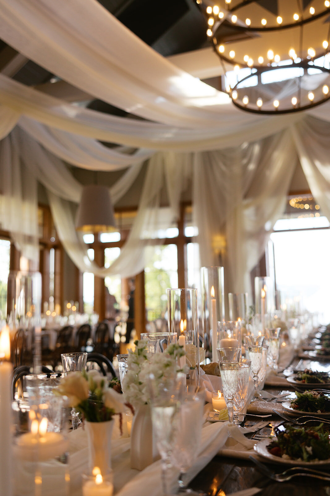 : Romantic wedding reception tablescape with candles, soft draping, and elegant place settings at Old Edwards Inn.

