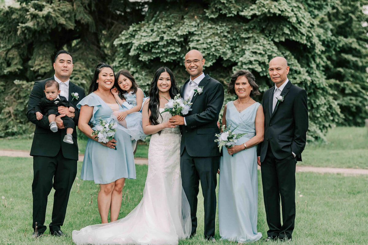 Bride and groom stand with groom's family.