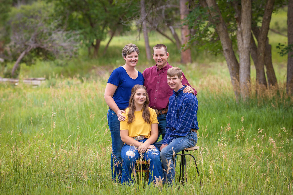 family of four standing in a field together