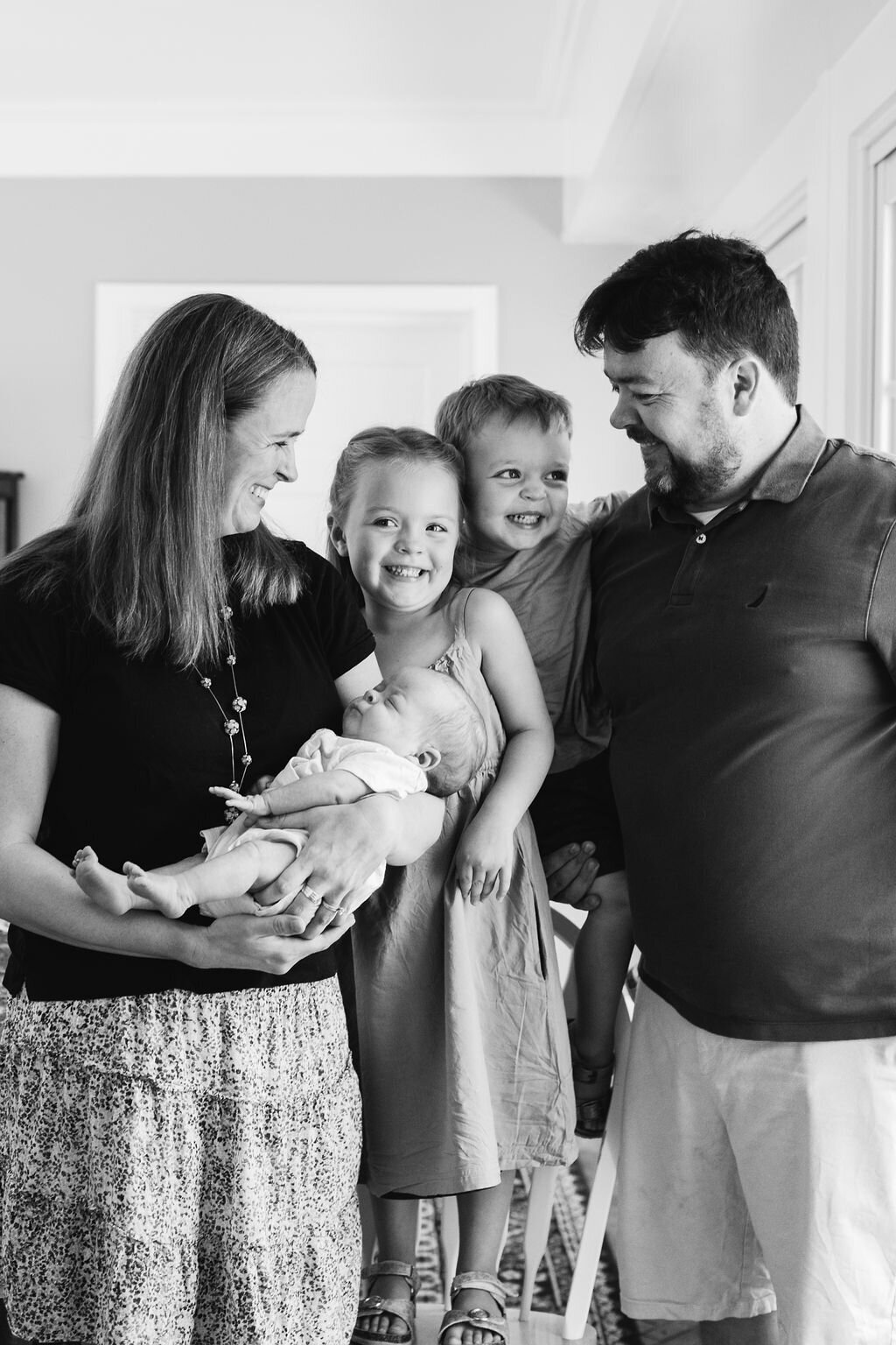 A family of five smiles.