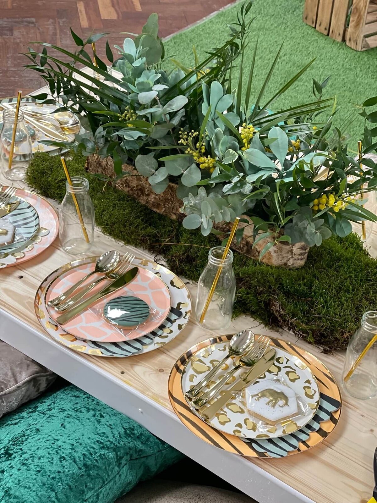 Kids party table settings with animal themed plates and biscuit table favours with glass milk bottles