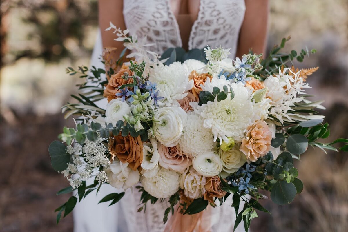 Faceless bride holds her lush bridal bouquet by Flowers and Thyme.