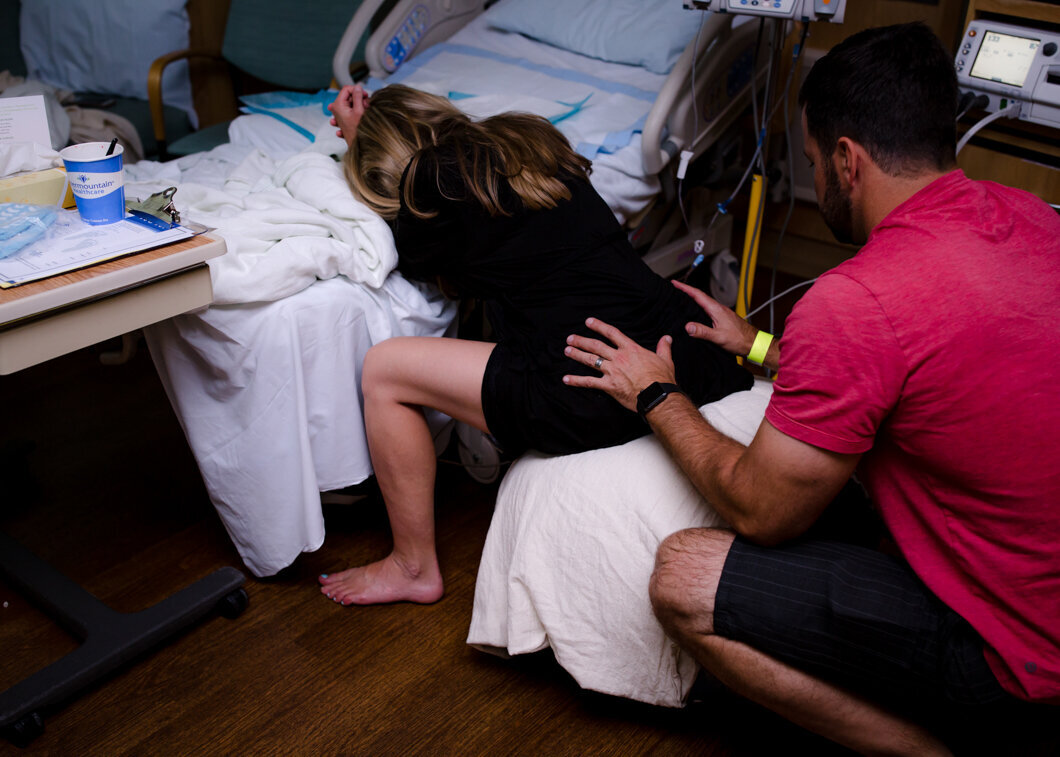 A husband give his wife a back rub while she labors in the hospital. Diane Owen