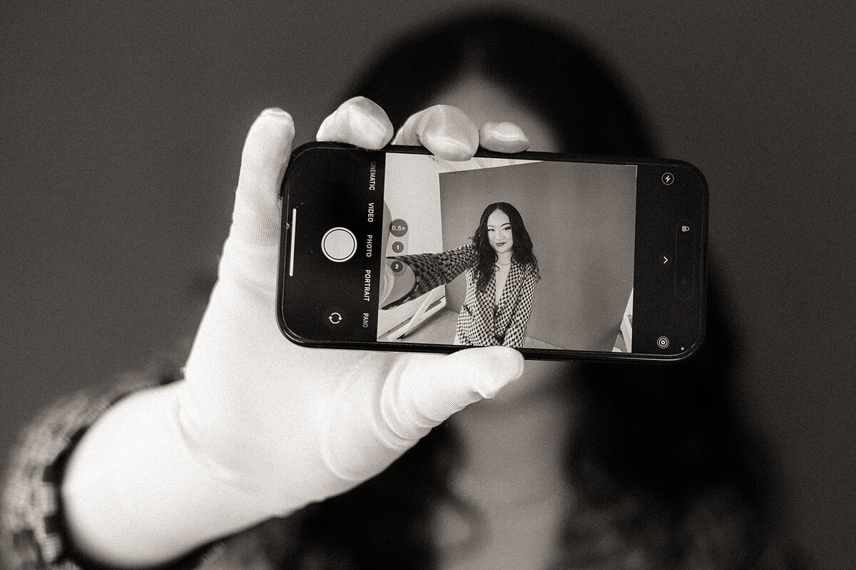 A woman takes a selfie with the phone pointed towards the viewer