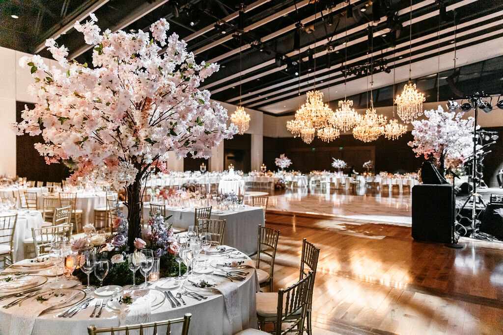 Cherry tree centerpieces with white linens and pink napkins