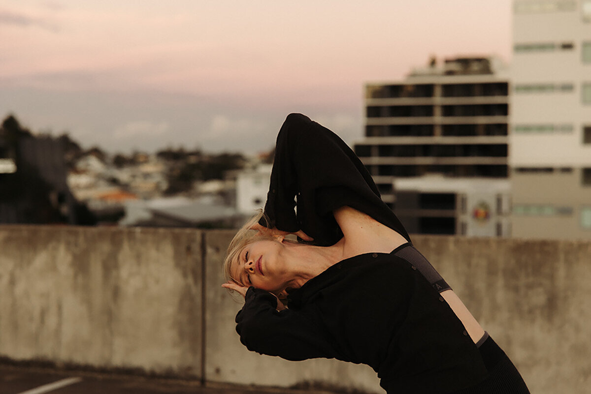 Authentic yoga branding photography featuring an instructor dancing outdoors at sunset.