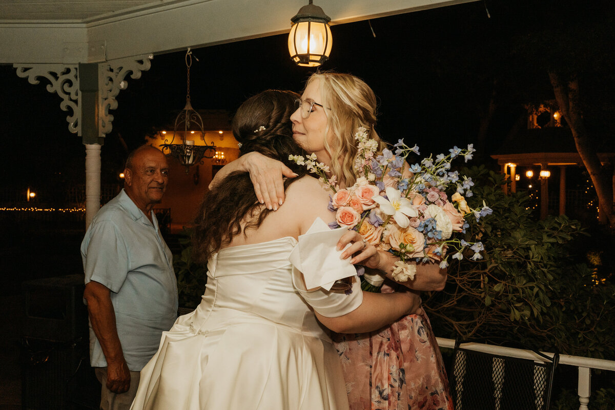 A newlywed person hugging one of their wedding guests
