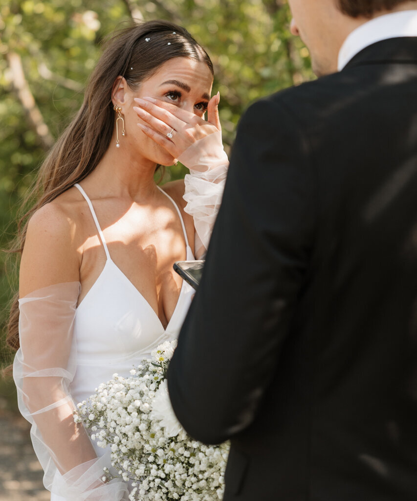Emotional bride reacts to groom’s vows, by Ninth Avenue Studios.