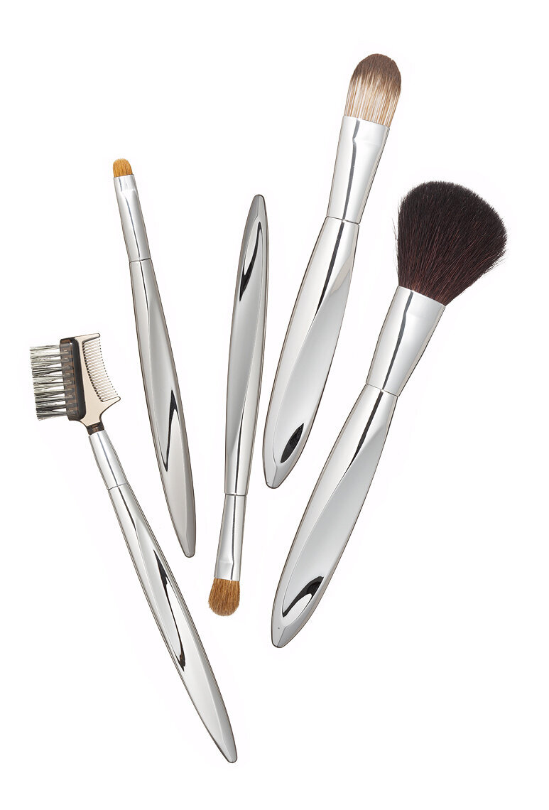 Elegant flat-lay of professional makeup brushes in a luxurious display, photographed by Ylva Erevall.