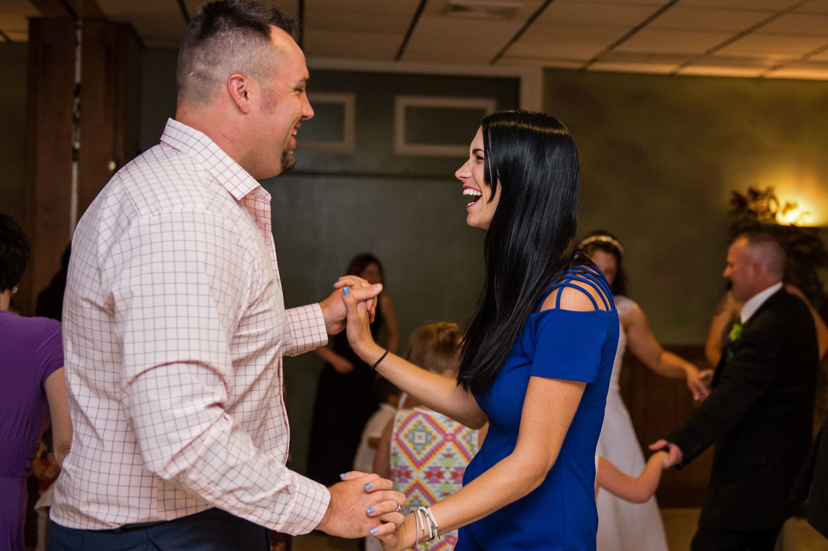 guests on dance floor holding hands laughing