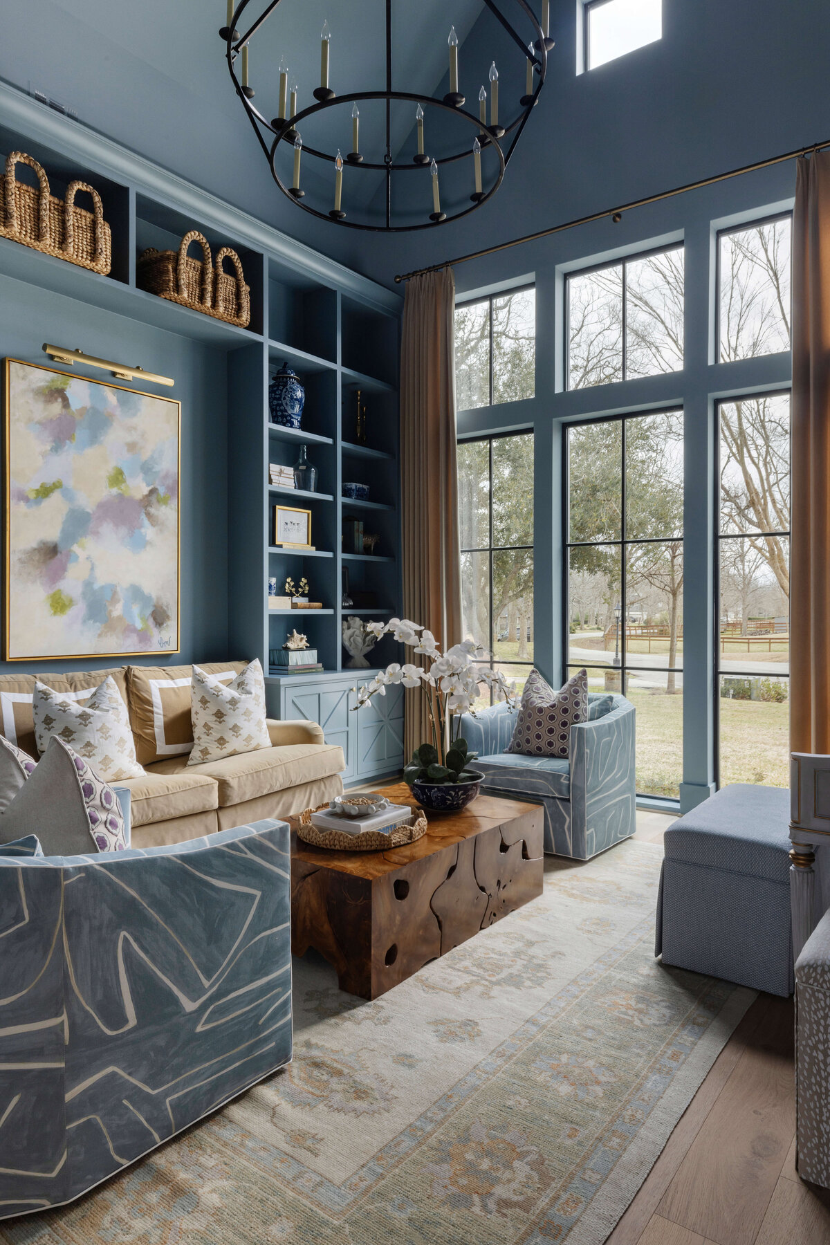 oyster creek studios missouri city new build living room with blue walls chandelier shelving and abstract painting
