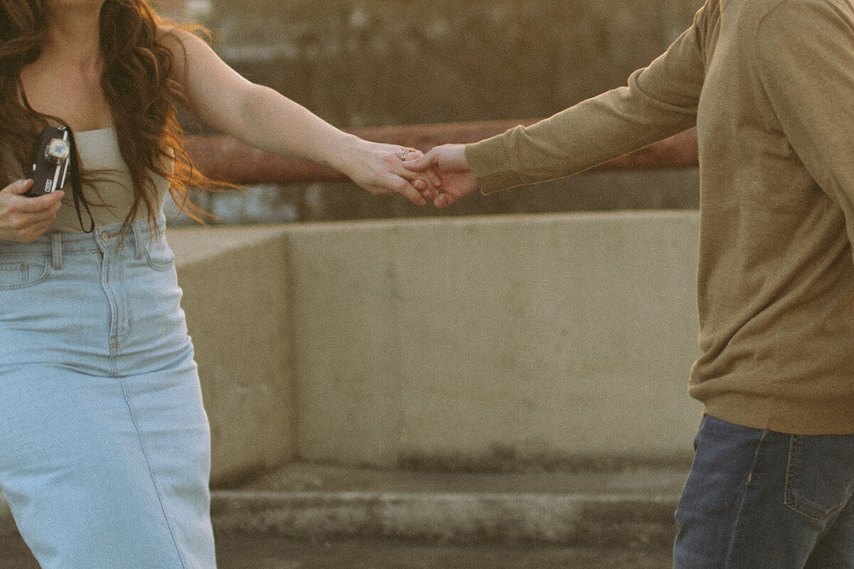 a couple holding hands on top of a parking garage.