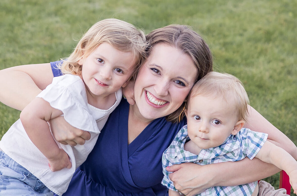 a woman in a blue dress with two toddlers