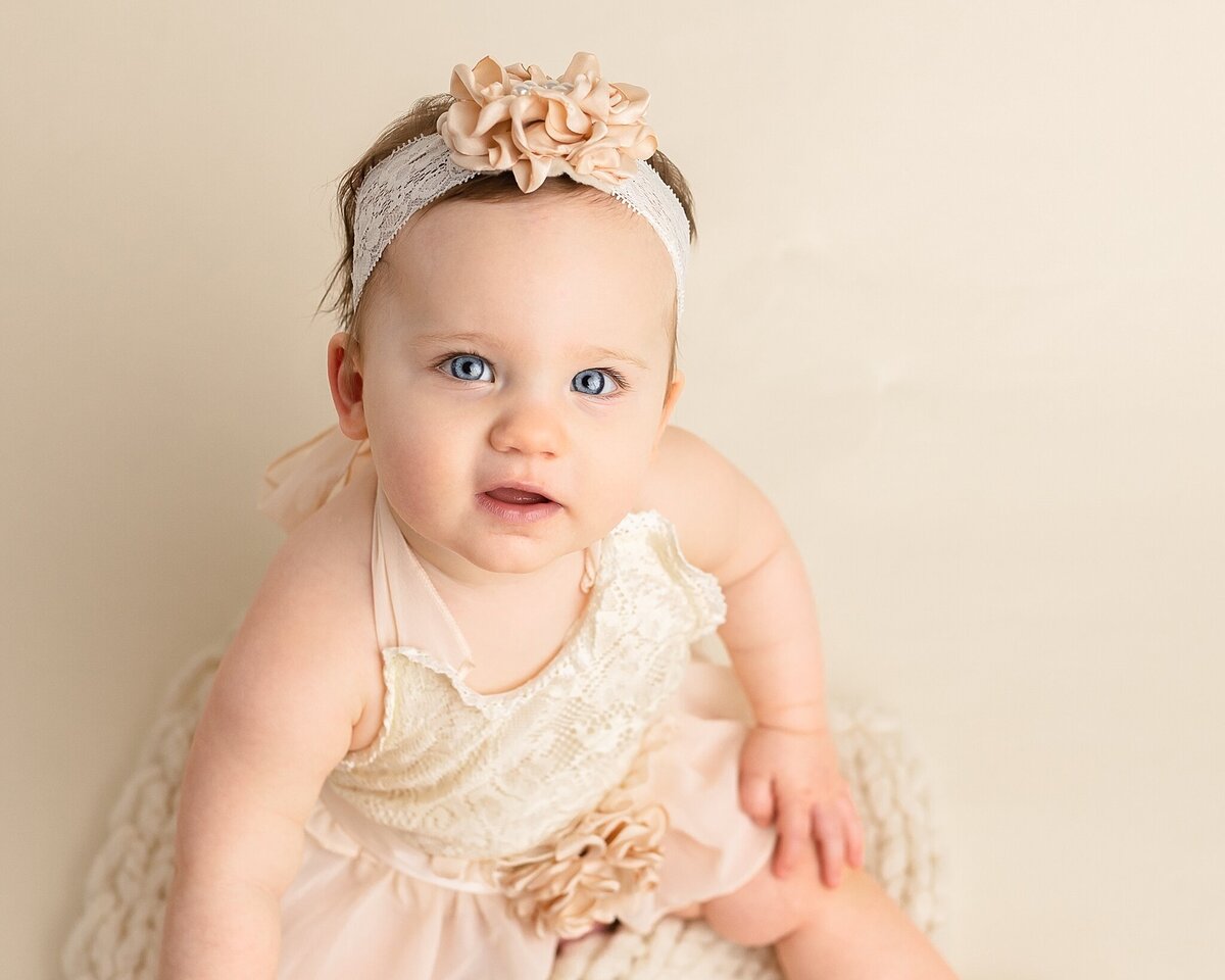 baby girl with blue eyes looking at camera in first birthday pictures in portland studio