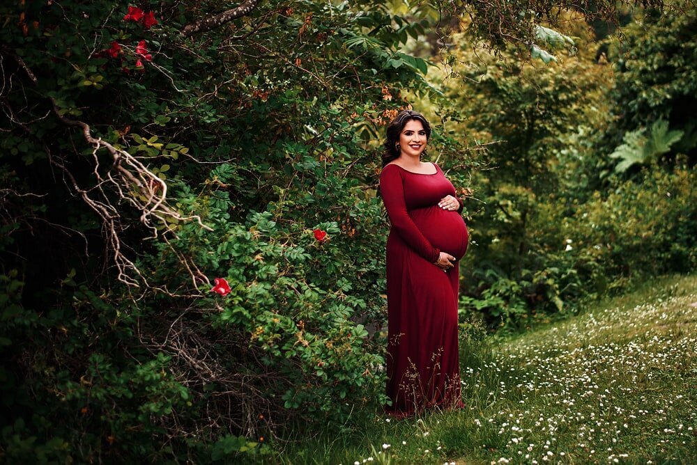 Woman in red dress at maternity photoshoot in Vancouver park
