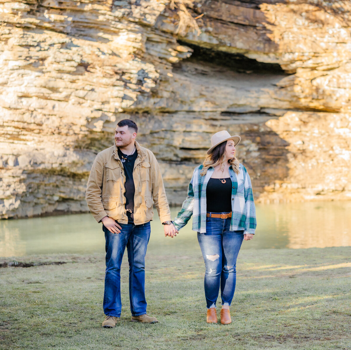 engaged couple looking in opposite directions while holding hands at fall creek falls state park