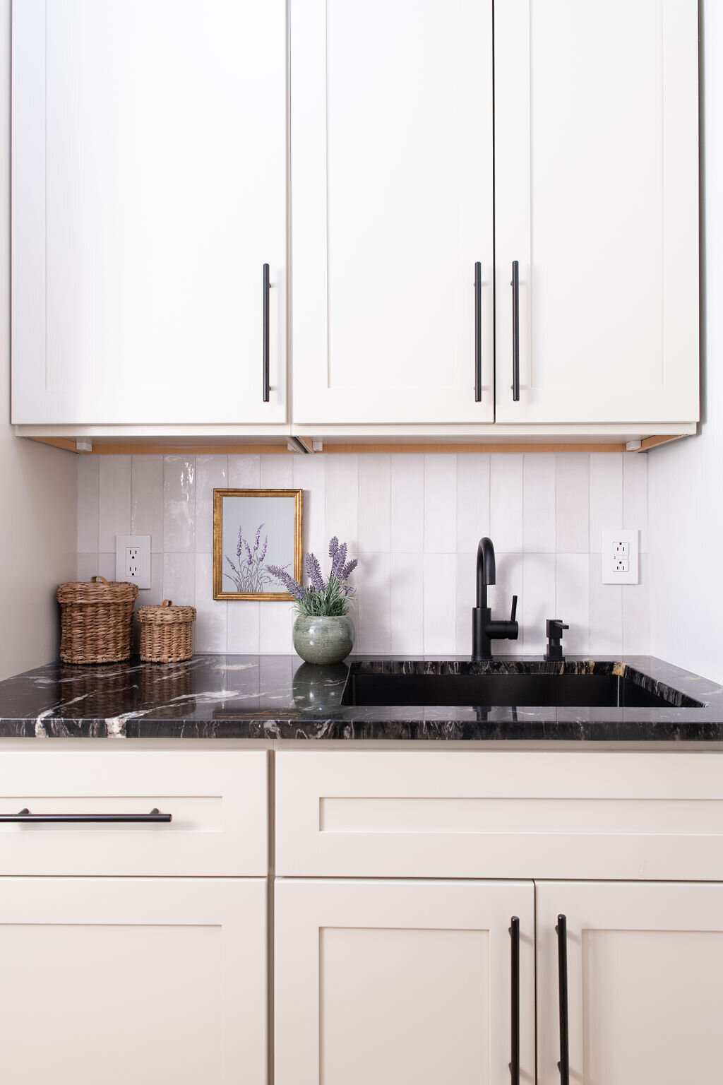 white cabinets with black handles and black countertops