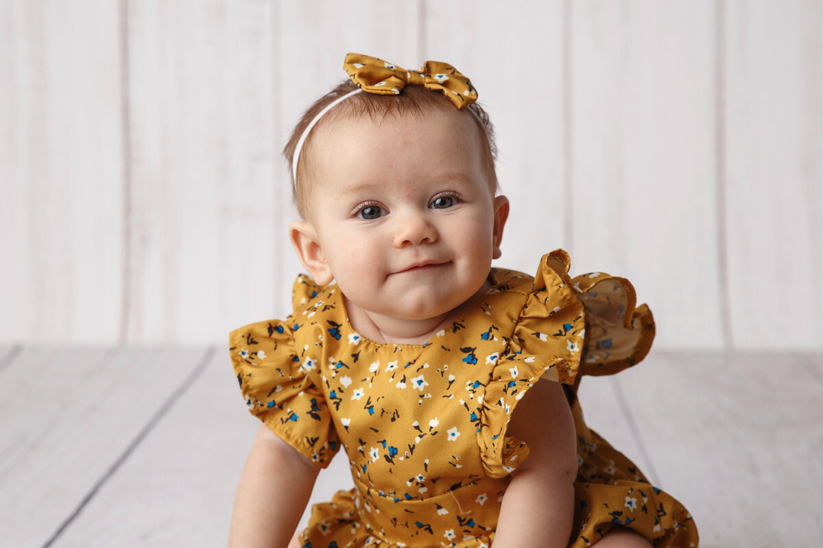 Closeup portrait of a baby girl wearing a yellow print dress photographed by Madison milestone Photographer, Life in Pink