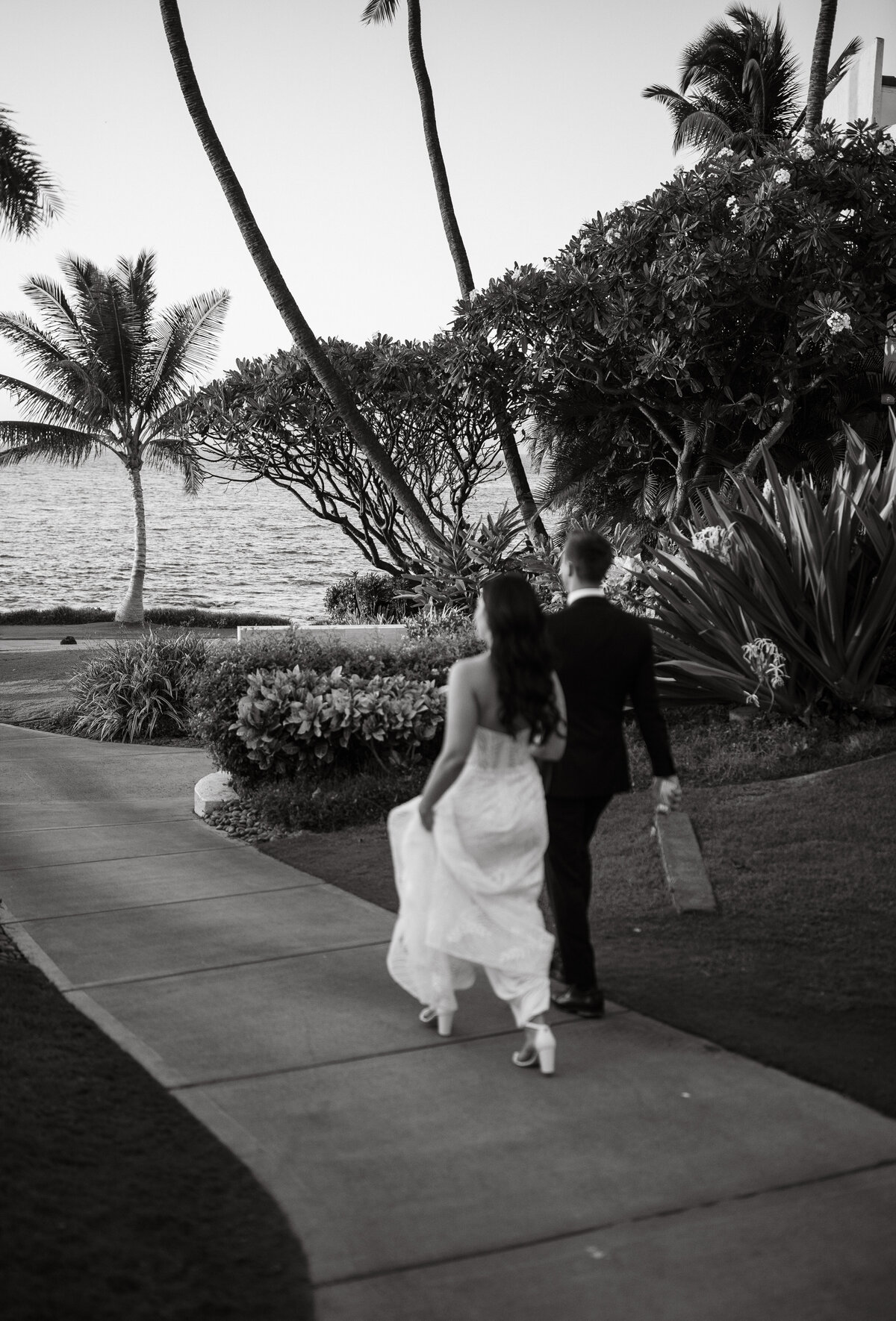 Wedding Photographer & Videographer, black and white image of bride and groom walking down pathway