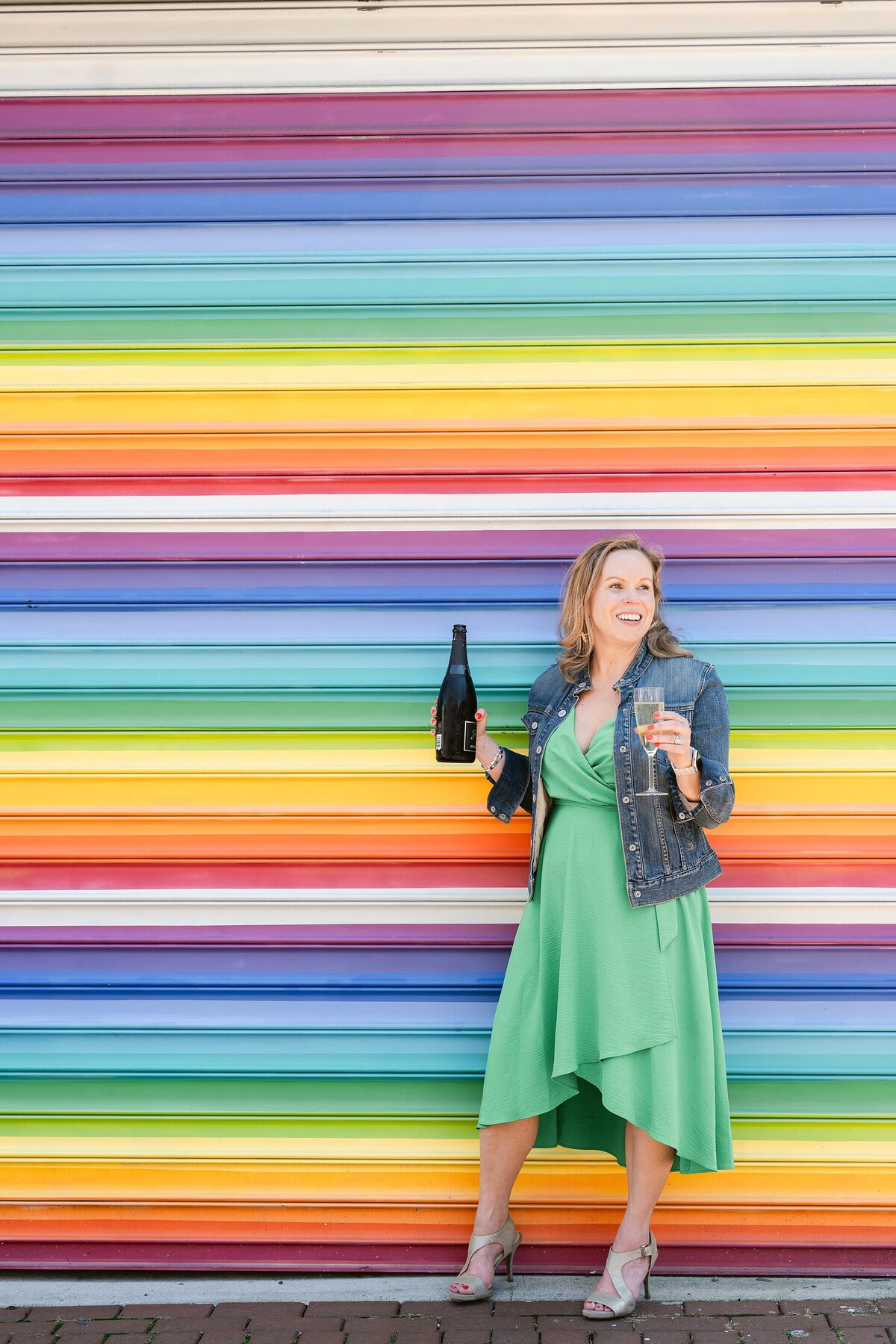 Woman with champagne in front of a bright wall