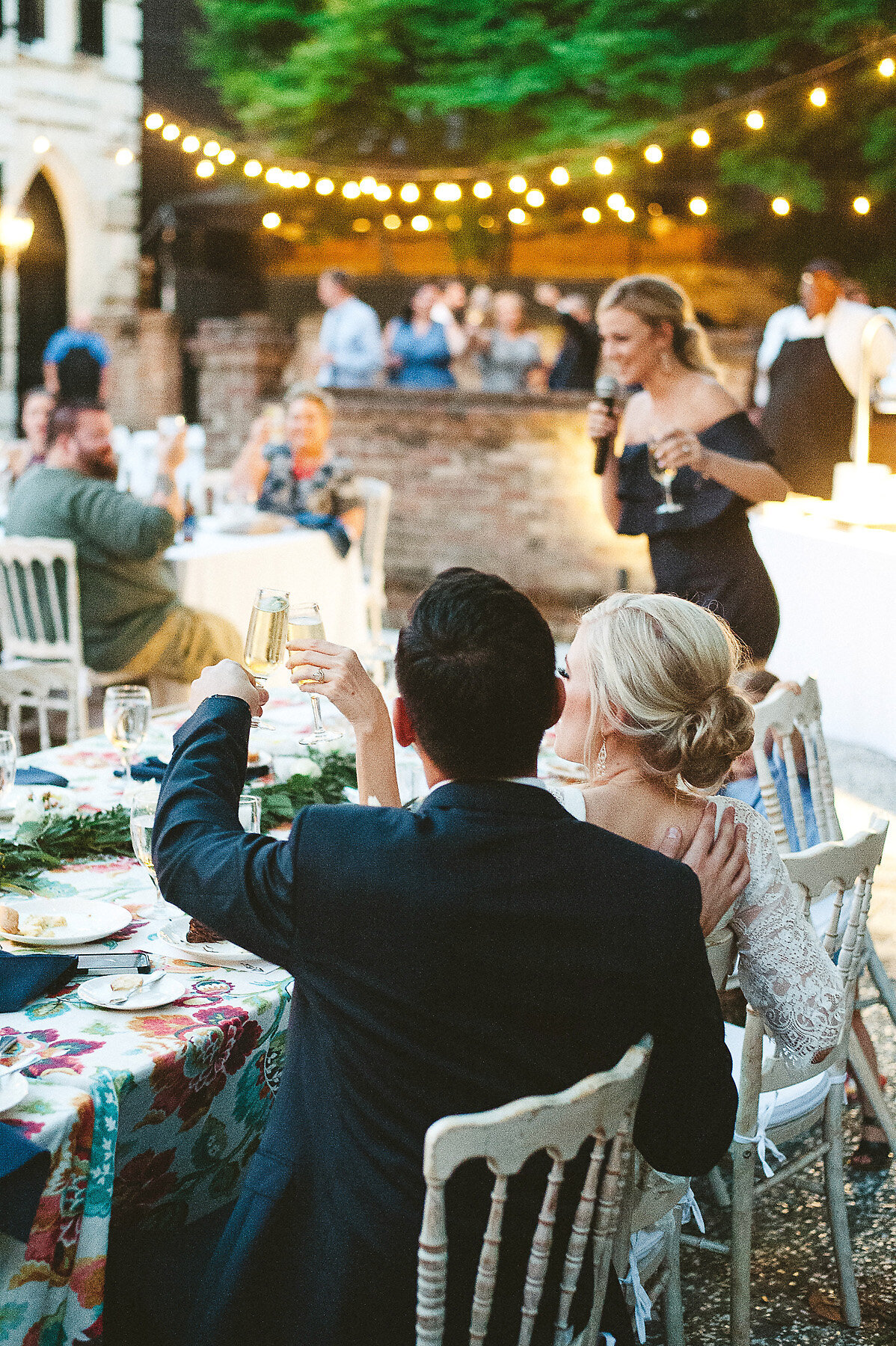 Groom toasting bride at wedding reception.