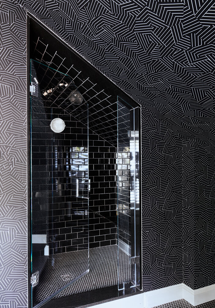 Kids bathroom design in an old home by a South Shore interior designer, featuring black tiles and Kelly Wearstler Schumacher wallpaper for a bold, playful look.