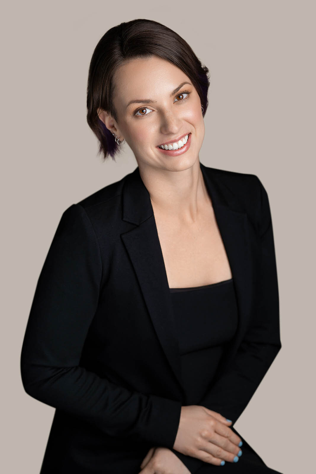A woman poses with a brigh smile for her headshots in Vancouver