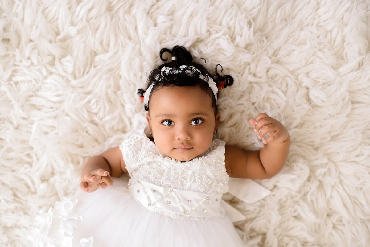 Baby girl in all white for 1st year milestone photoshoot