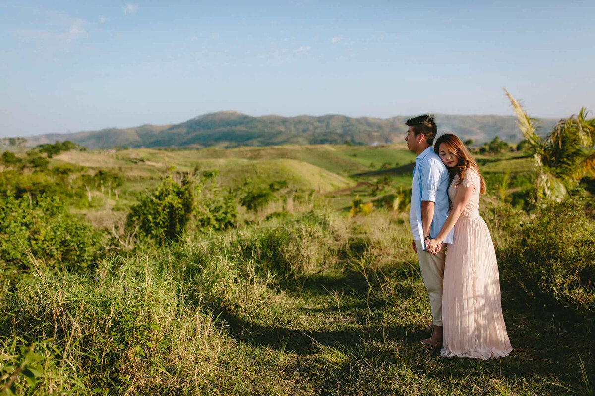 couple looking out at view of grassy hills