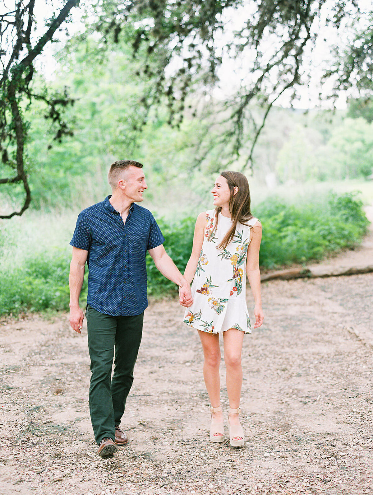 couple walks together under a giant oak tree at Bull Creek