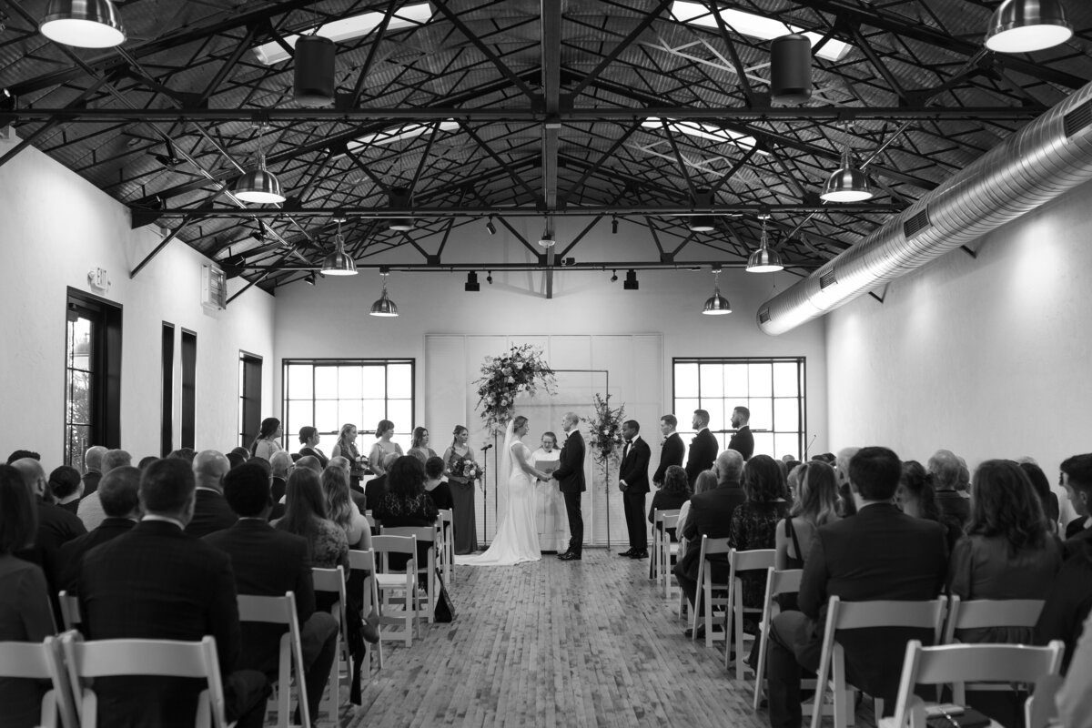 The couple’s Madison ceremony setup in The Tinsmith’s greenhouse space, featuring elegant florals and industrial-inspired decor.