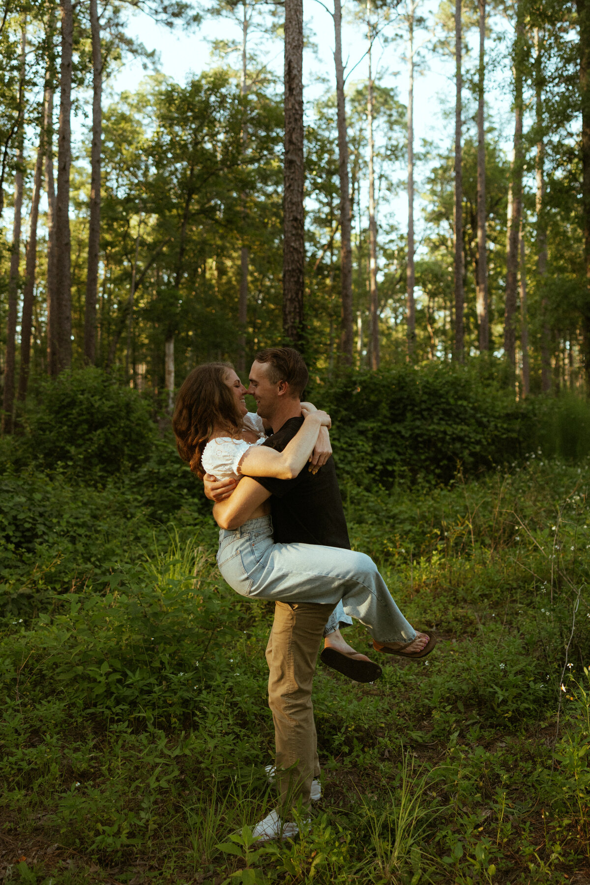 Couple posing for portraits in a forest.
