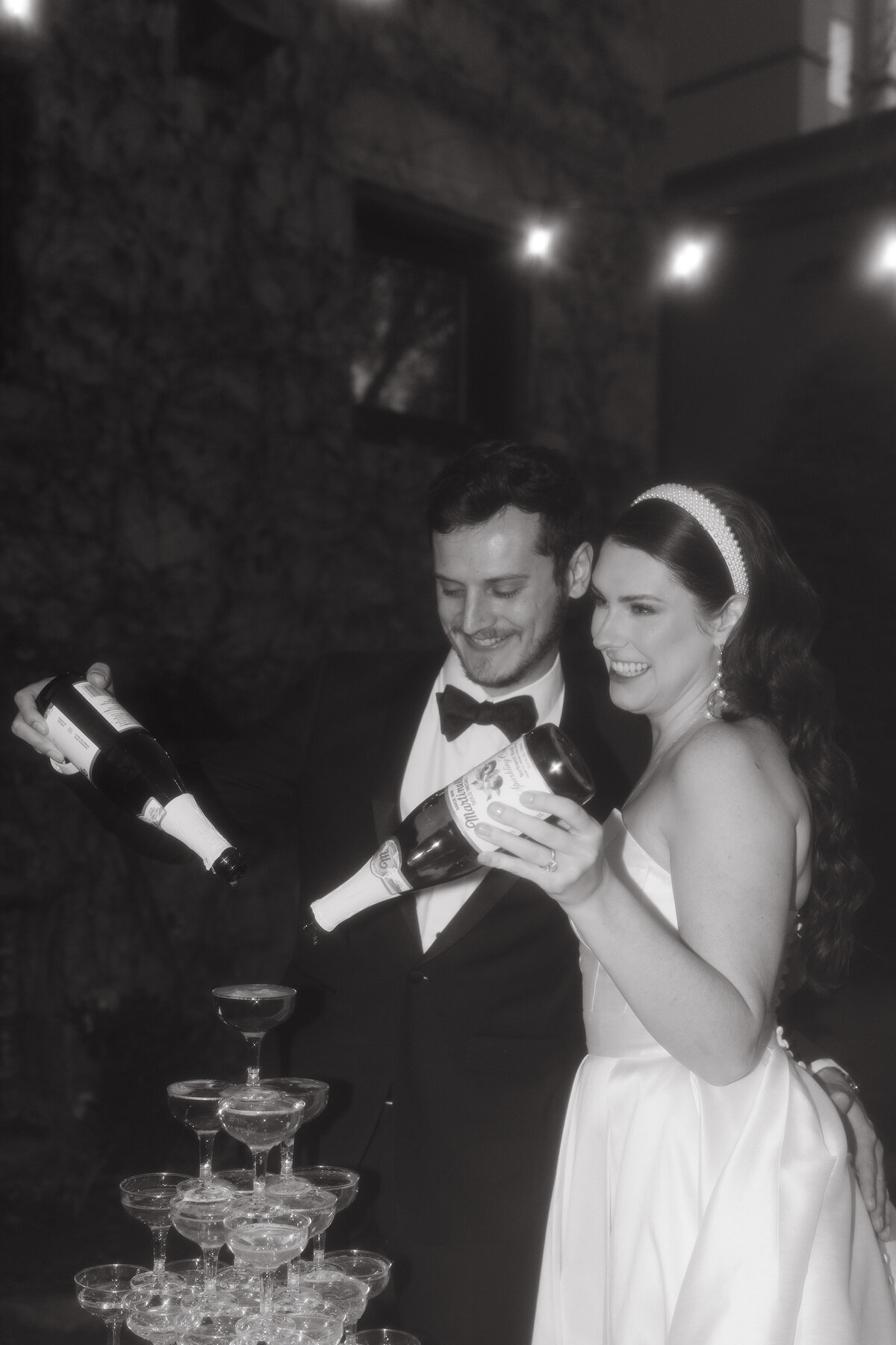 couples pours champagne into glasses