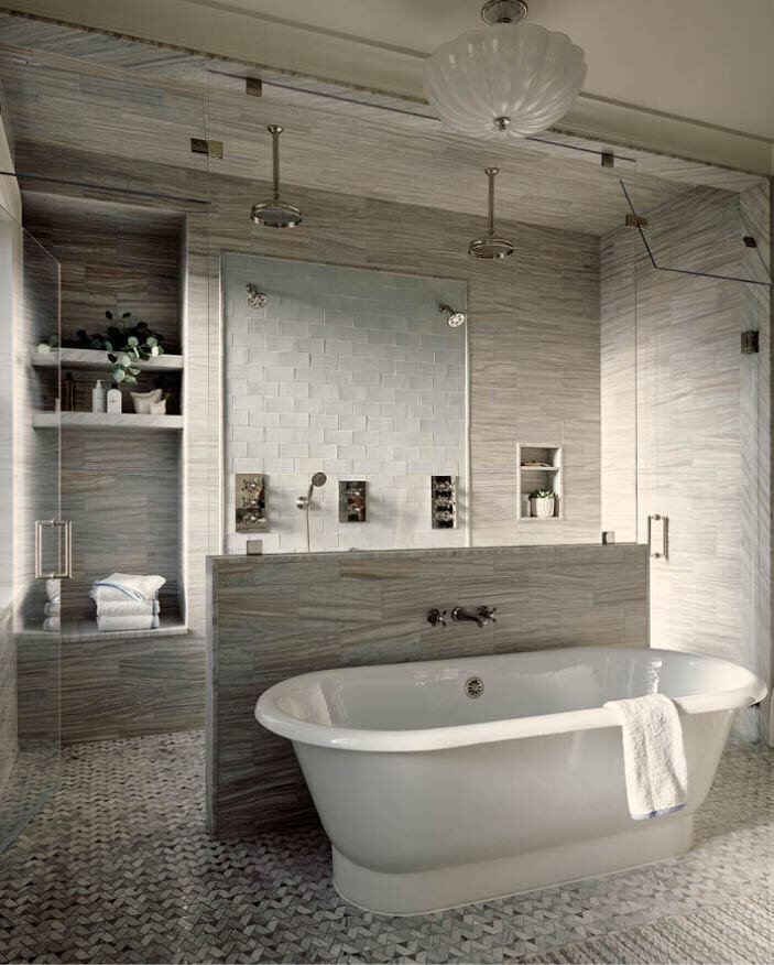 A curbless shower with light grey mosaic tile, freestanding tub, and double shower with wall and ceiling heads create a luxurious bathroom. By Sarah Scales.