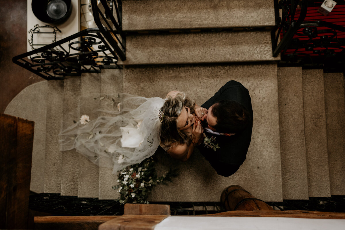 bride and groom standing together on a staircase