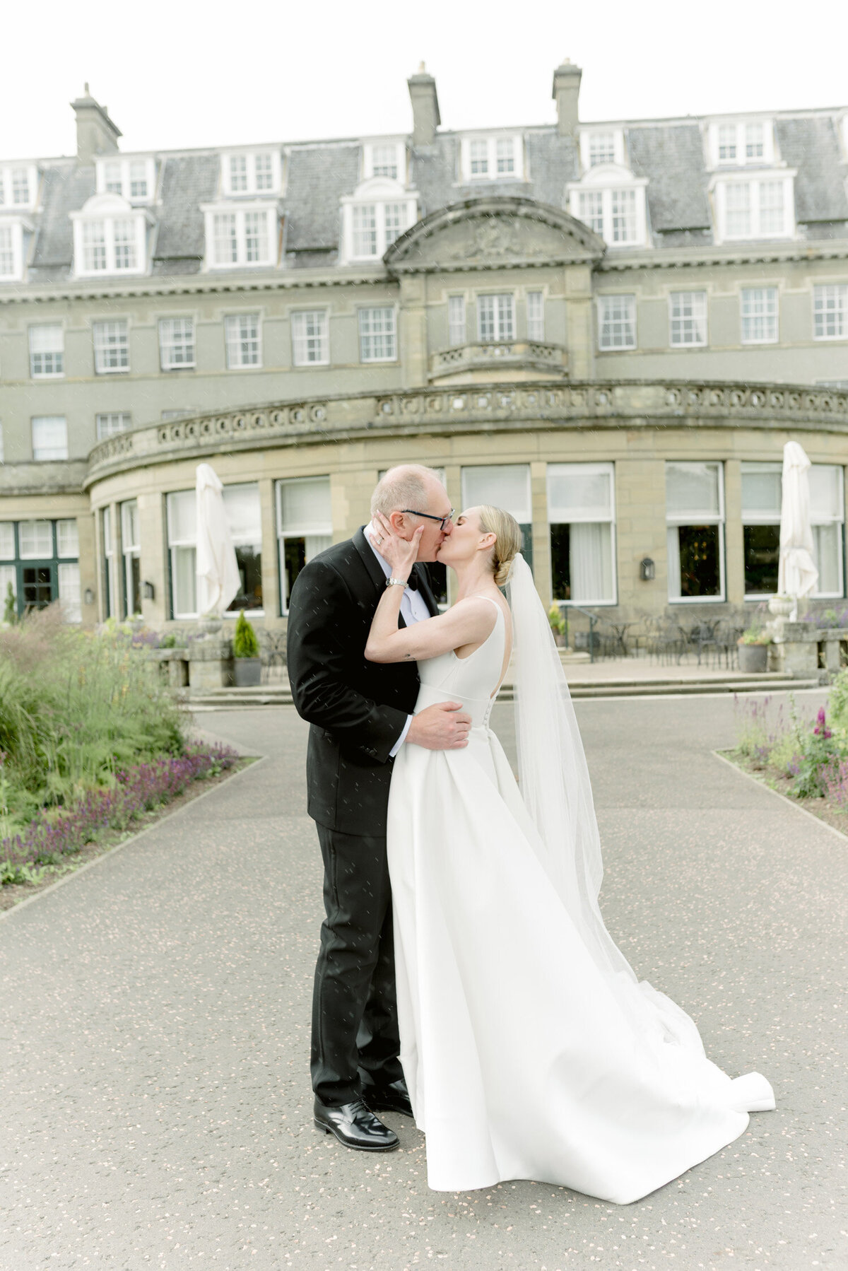 Bride and Groom kiss in the ground of Gleneagles Hotel on their wedding day. Image by Gleneagles wedding photographer, Jill Cherry Porter.