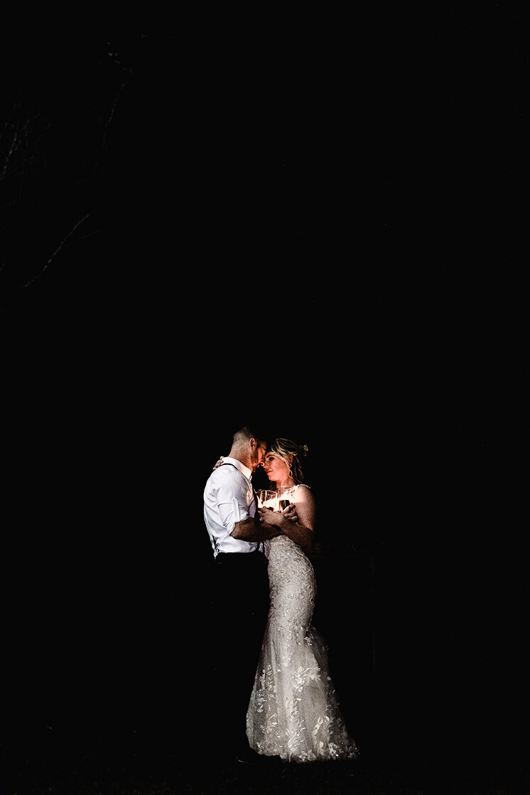 Intimate night photo with bride and groom hugging while holding candles at Wentworth Inn wedding in Jackson NH by Lisa Smith Photography