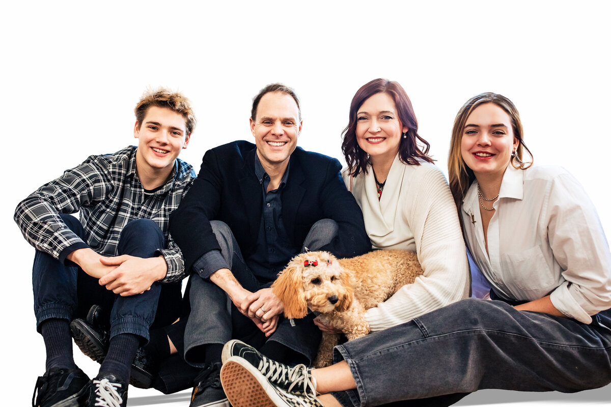 A family of 4 and a curly yellow dog pose for a sharp portrait at the Pittsburgh Photography Studio on Bright white background.
