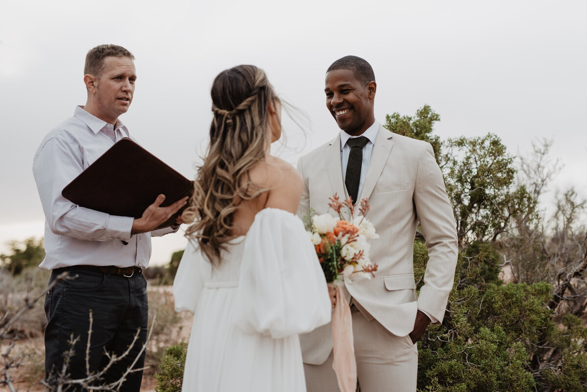Utah Elopement Photographer captures groom smiling at bride during intimate elopement ceremony