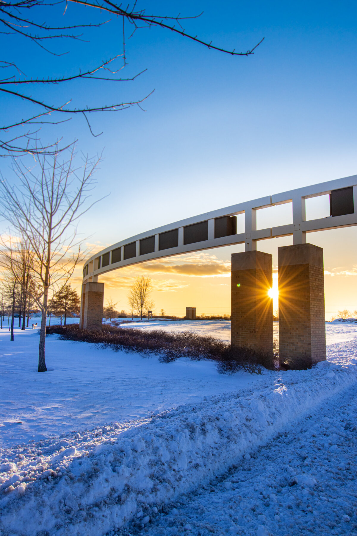 021621 Snowfest snowday sunset starburst golden hour at the gateway tall format