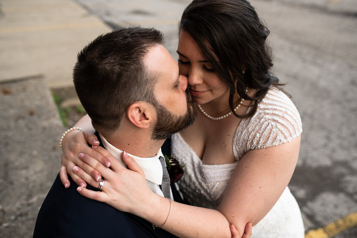 Bride and groom sit close after their wedding ceremony for portraits