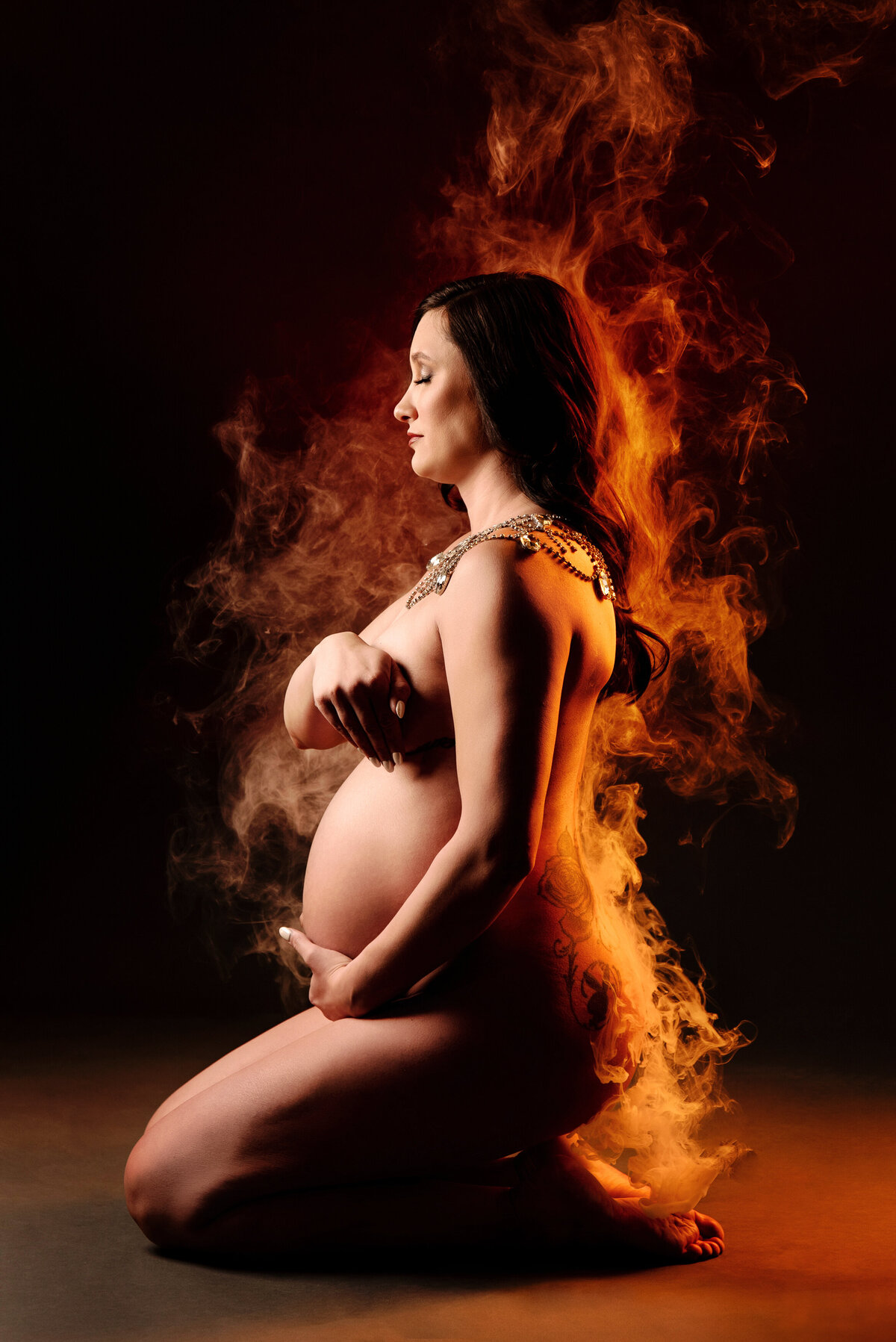 st-louis-maternity-photographer-nude-pregnant-mom-on-knees-with-smoke-that-looks-like-she-is-on-fire