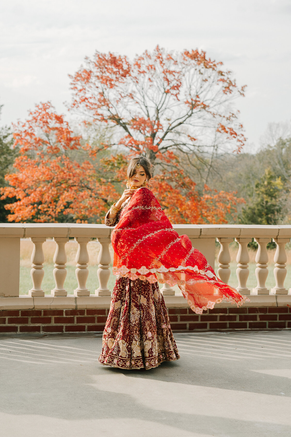 An indian bride in a red sari twirls in circles
