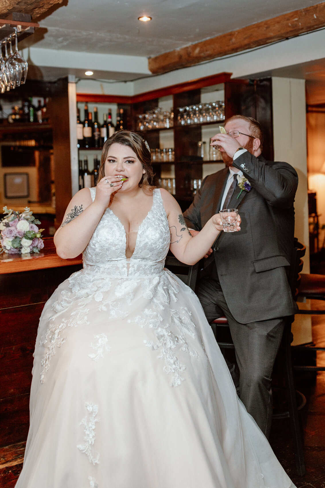A couple takes tequila shots at the bar at Red Lion Inn. Candid wedding photography