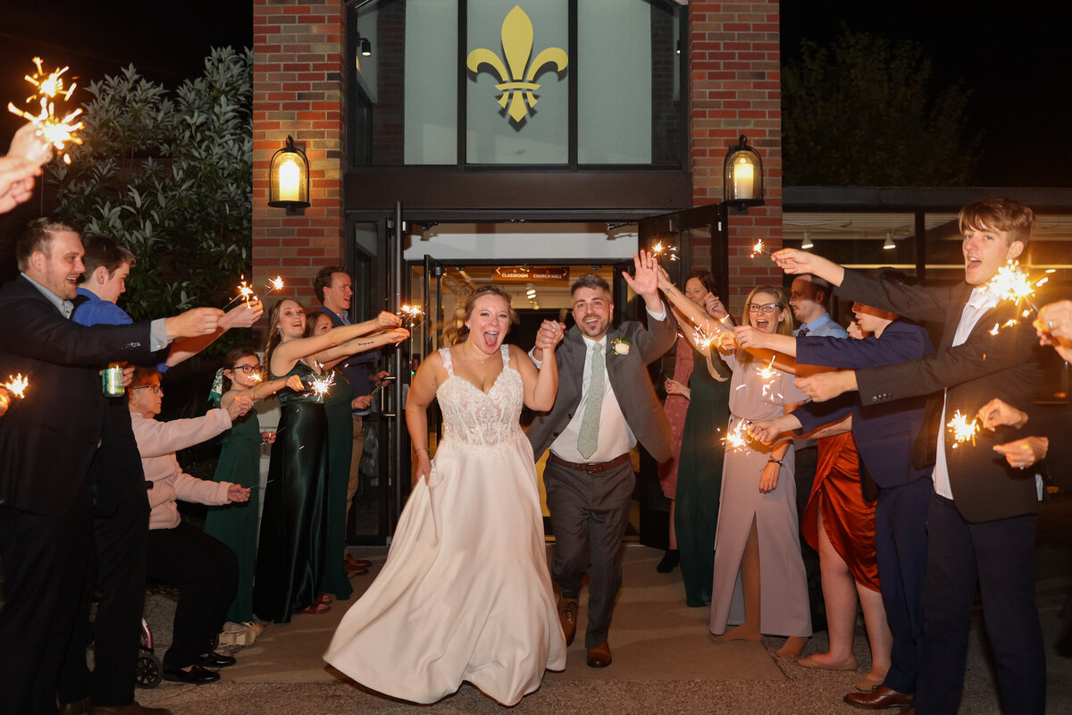 bride and groom exiting their wedding with sparklers at Sojourn Church in New Albany Indiana by Lousiville wedding photographer Amanda Richardson Photography