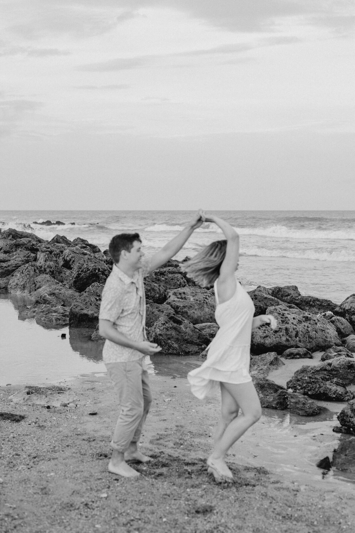 Couple dancing romantically on Wilmington beach, elegant engagement photo