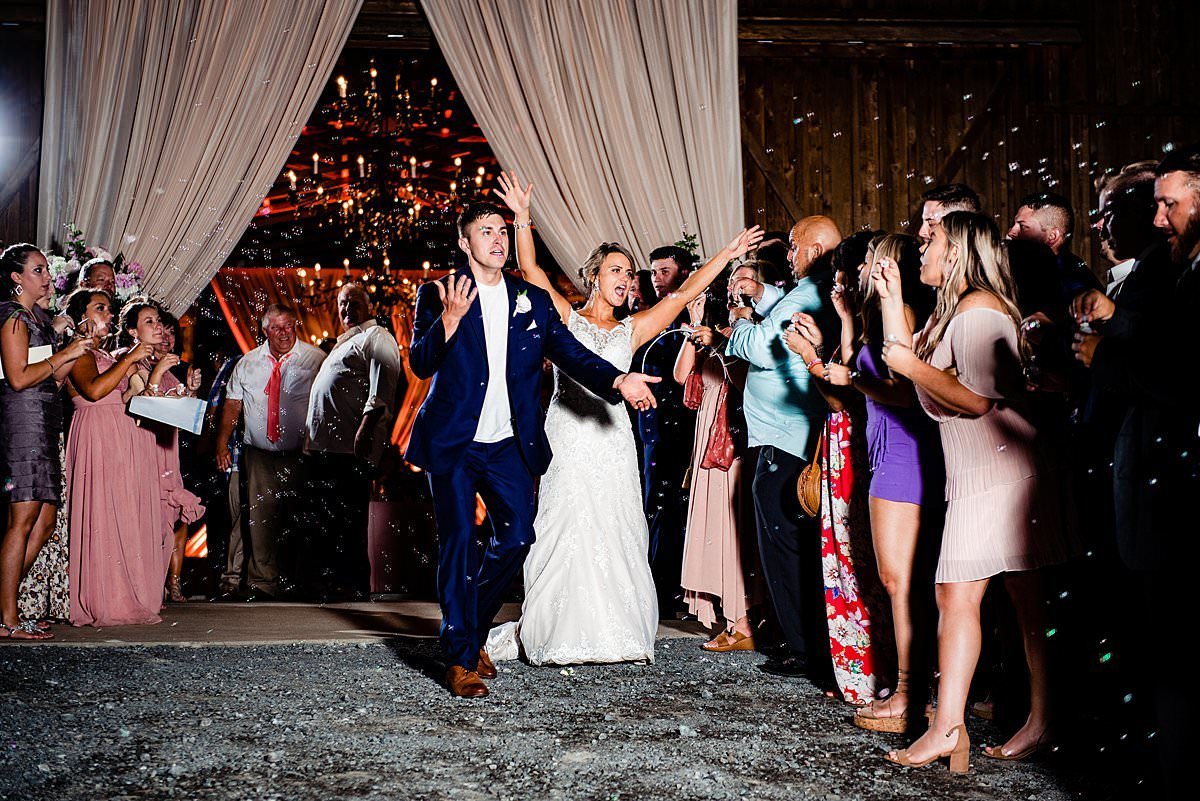 Bride and groom exiting their reception with bubbles